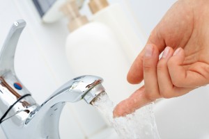 stock-photo-close-up-of-human-finger-trying-how-hot-the-water-is-88835011